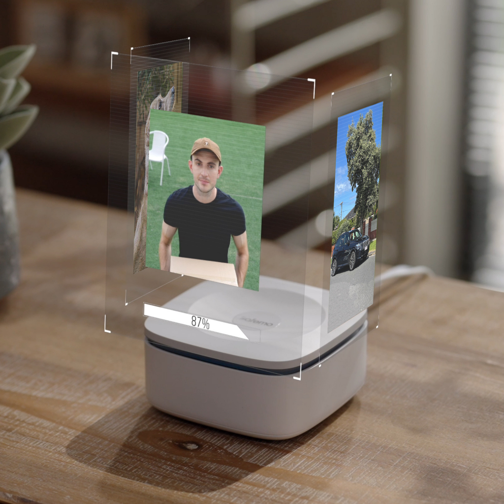 Produktbild des Smart Hub Aufzeichnungsrekorders auf einem Holztisch mit virtuell dargestellten Bildern einer Überwachungskamera darüber