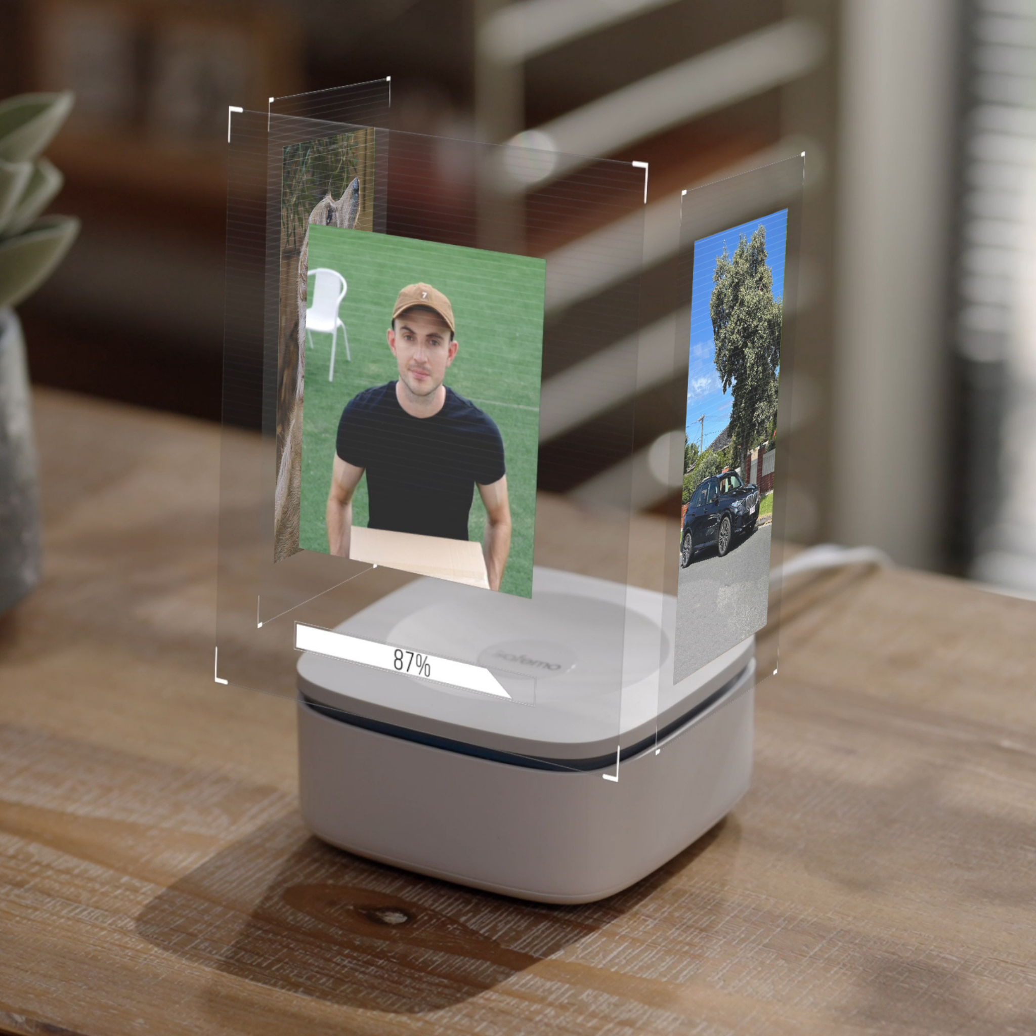 Produktbild des Smart Hub Aufzeichnungsrekorders auf einem Holztisch mit virtuell dargestellten Bildern einer Überwachungskamera darüber